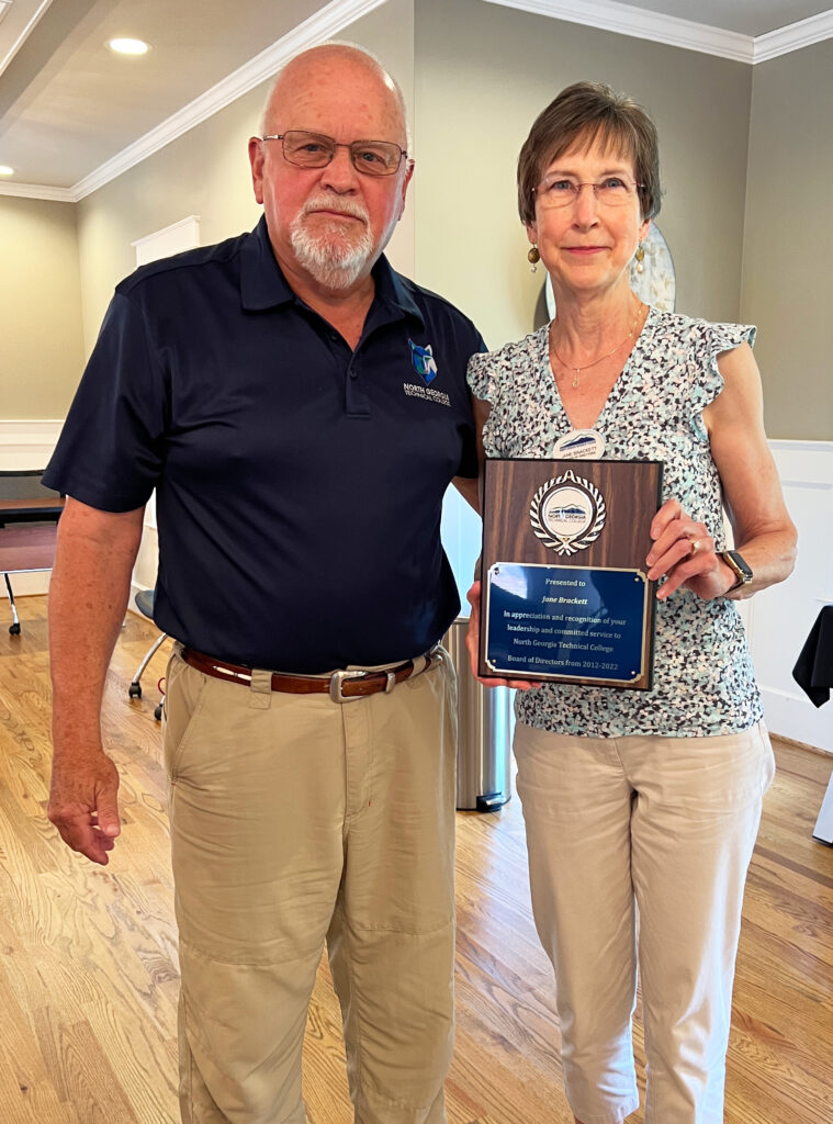 Pictured (left to right): NGTC Board of Directors chair Mitchel Barrett presents Board of Directors member Jane Brackett with a commemorative plaque recognizing her 10 years of service. 